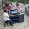 3-personer-konverserar-och-grillar-mat-pa-en-gasolgrill-sahara-arke-3-brannare-gra